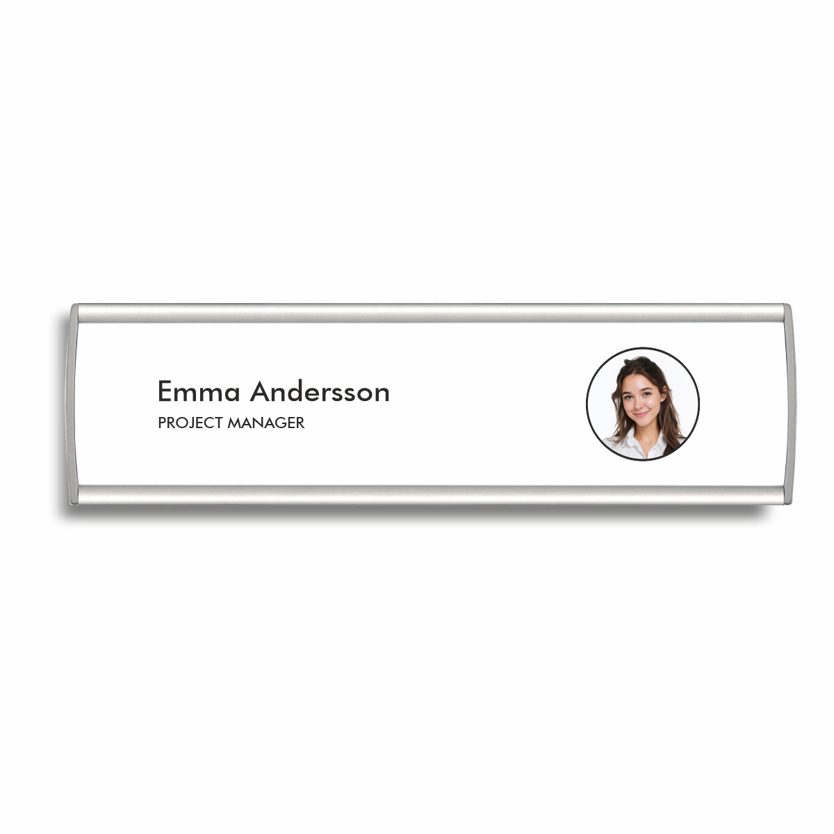 Välvd namnskylt med aluminiumram i storlek 200 x 53 mm med grå ändstycken, med en bild på en kvinna och hennes namn och yrke tryckt på skylten