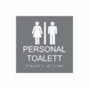 Grå och vit skylt för personaltoalett med piktogram av en kvinna och en man åtskilda av ett lodrätt streck, texten personal toalett står under symbolen och punktskrift längst ned
