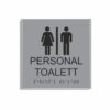 Silvergrå och svart skylt för personaltoalett i storlek 150 x 150 mm med en tunn aluminiumram, med piktogram av en kvinna och en man åtskilda av ett lodrätt streck, texten personal toalett står under symbolen och punktskrift längst ned
