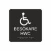 Svart och vit toalettskylt för besökare hwc med piktogram av en rullstol, texten besökare hwc står under symbolen och punktskrift längst ned