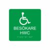 Grön och vit toalettskylt för besökare hwc med piktogram av en rullstol, texten besökare hwc står under symbolen och punktskrift längst ned