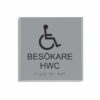 Silvergrå och svart toalettskylt för besökare hwc i storlek 150 x 150 mm med en tunn aluminiumram, med piktogram av en rullstol, texten besökare hwc står under symbolen och punktskrift längst ned